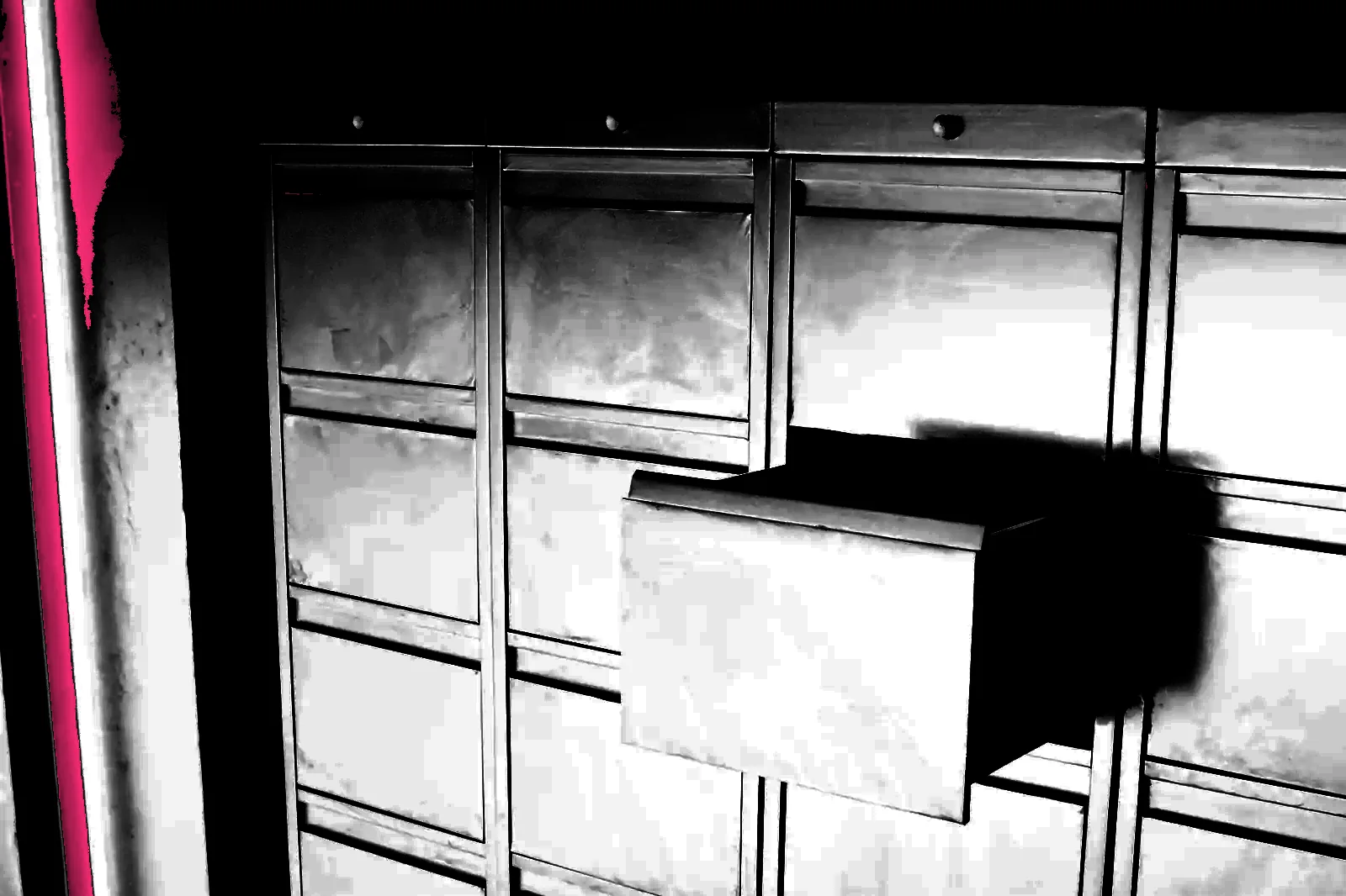 A bank of metal filing drawers, one pulled open