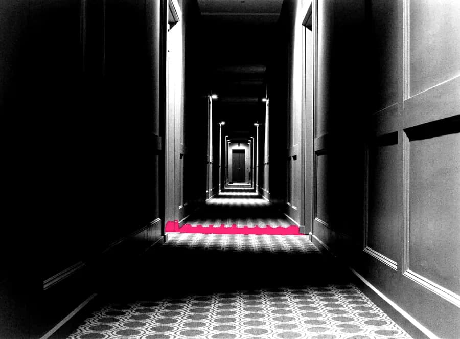 An empty hotel corridor at night, doors receding into darkness